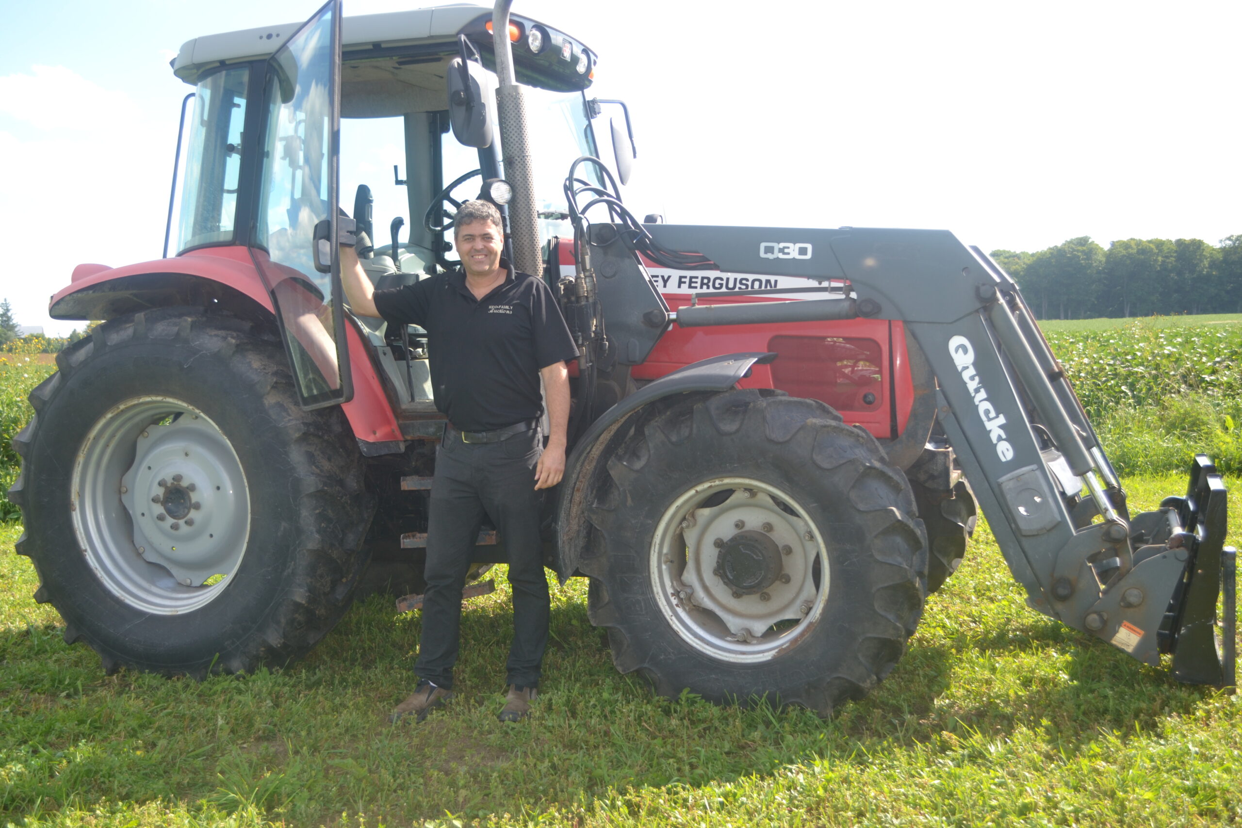 Dennis outdoors with farming equipment.
