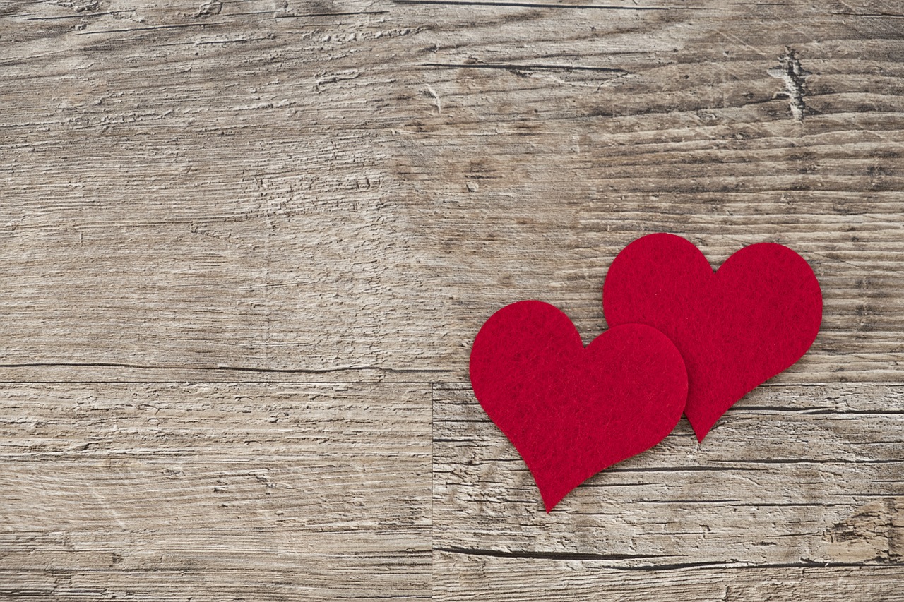 TWO RED HEARTS AGAINST WOOD BACKDROP