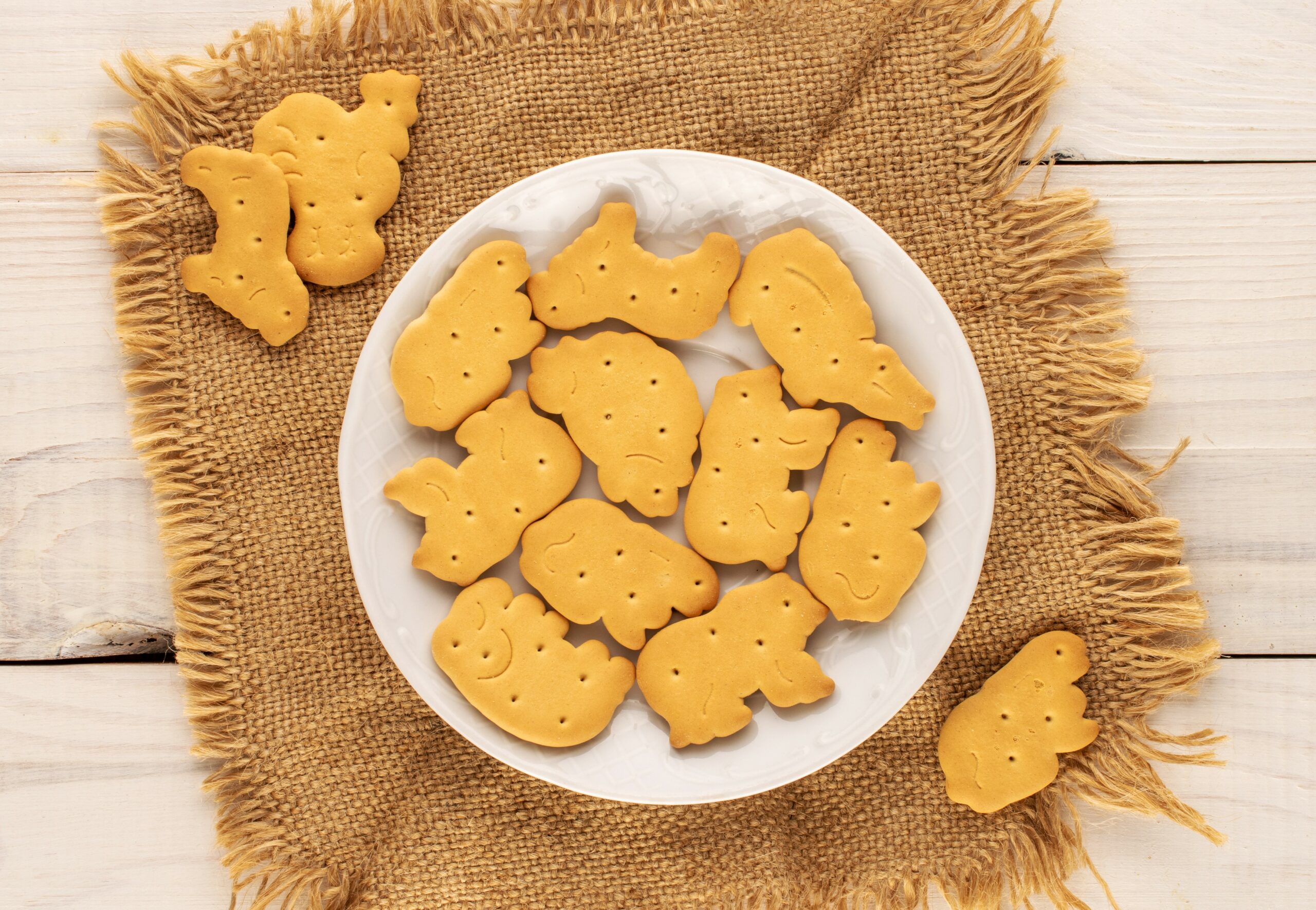 Animal crackers on a plate on a piece of burlap