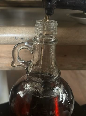 maple syrup pouring into jug