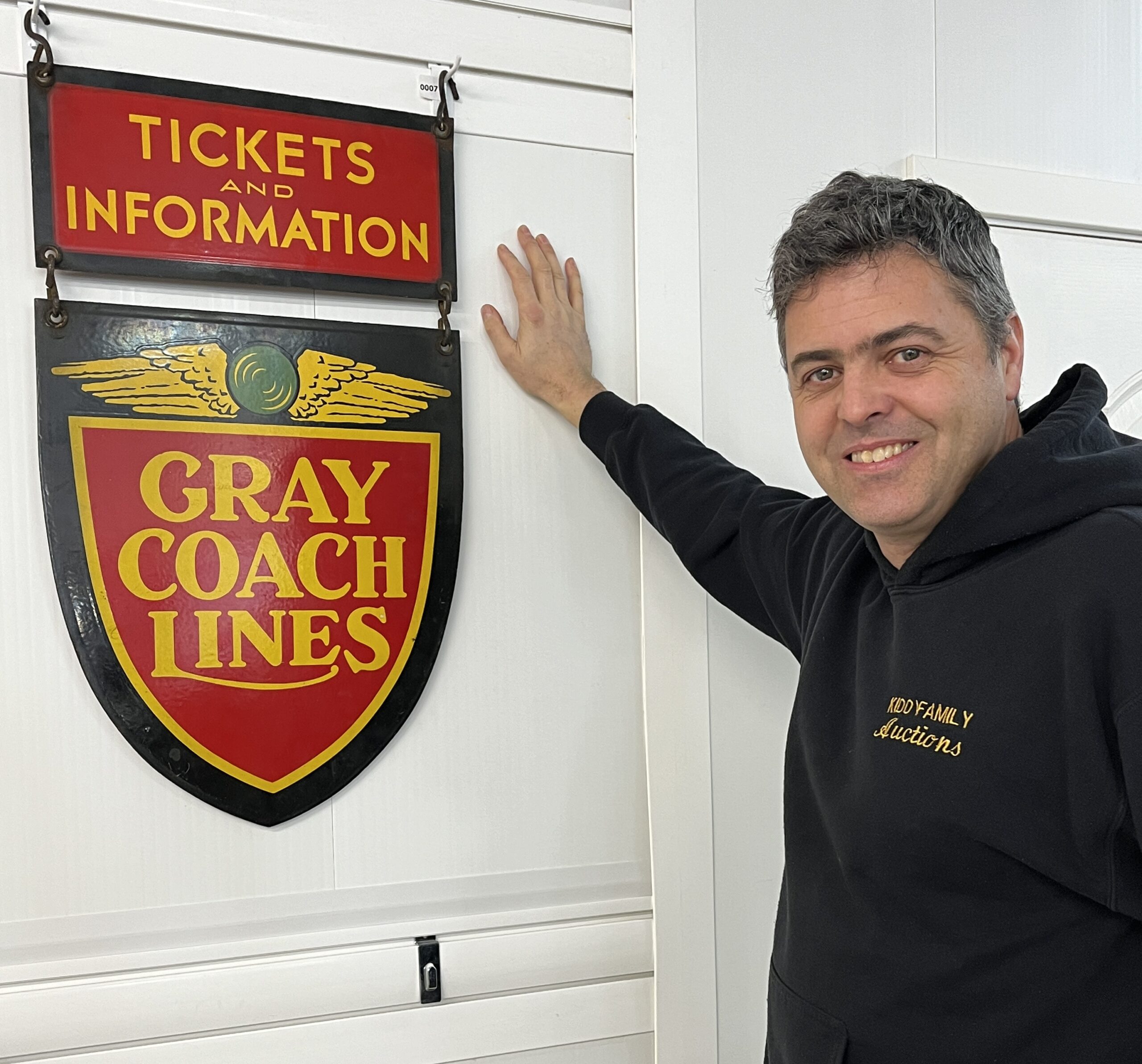 Dennis smiling with Gray Coach Lines Sign