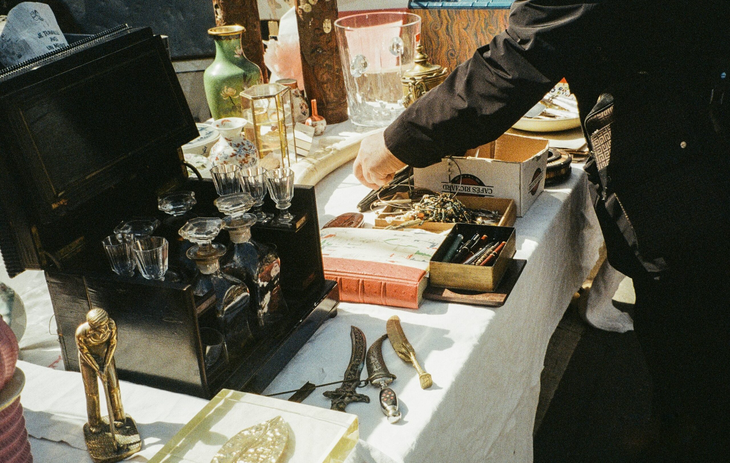 zoomed in view someone browsing antiques on a table