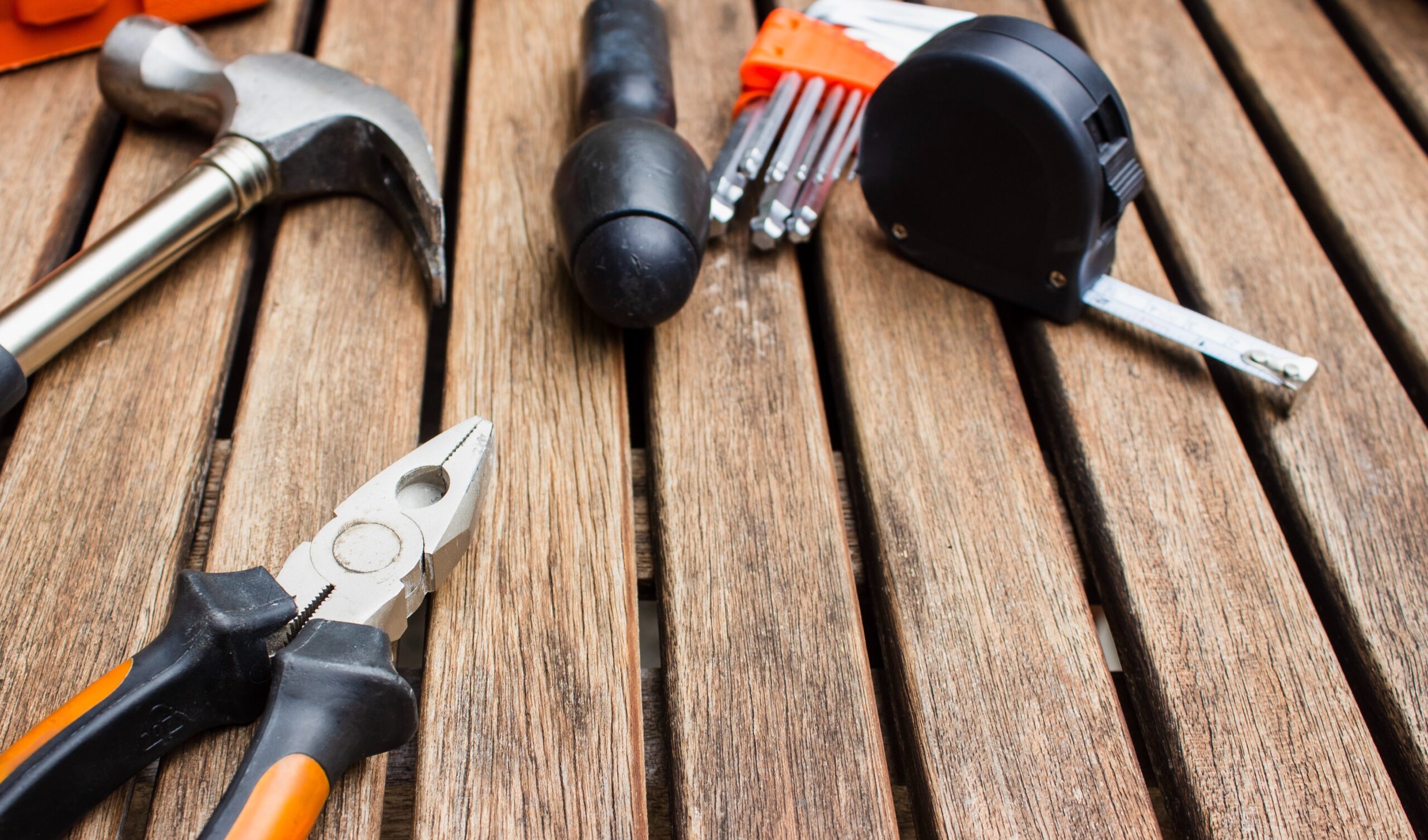 close up of assorted tools spread out across wood planks