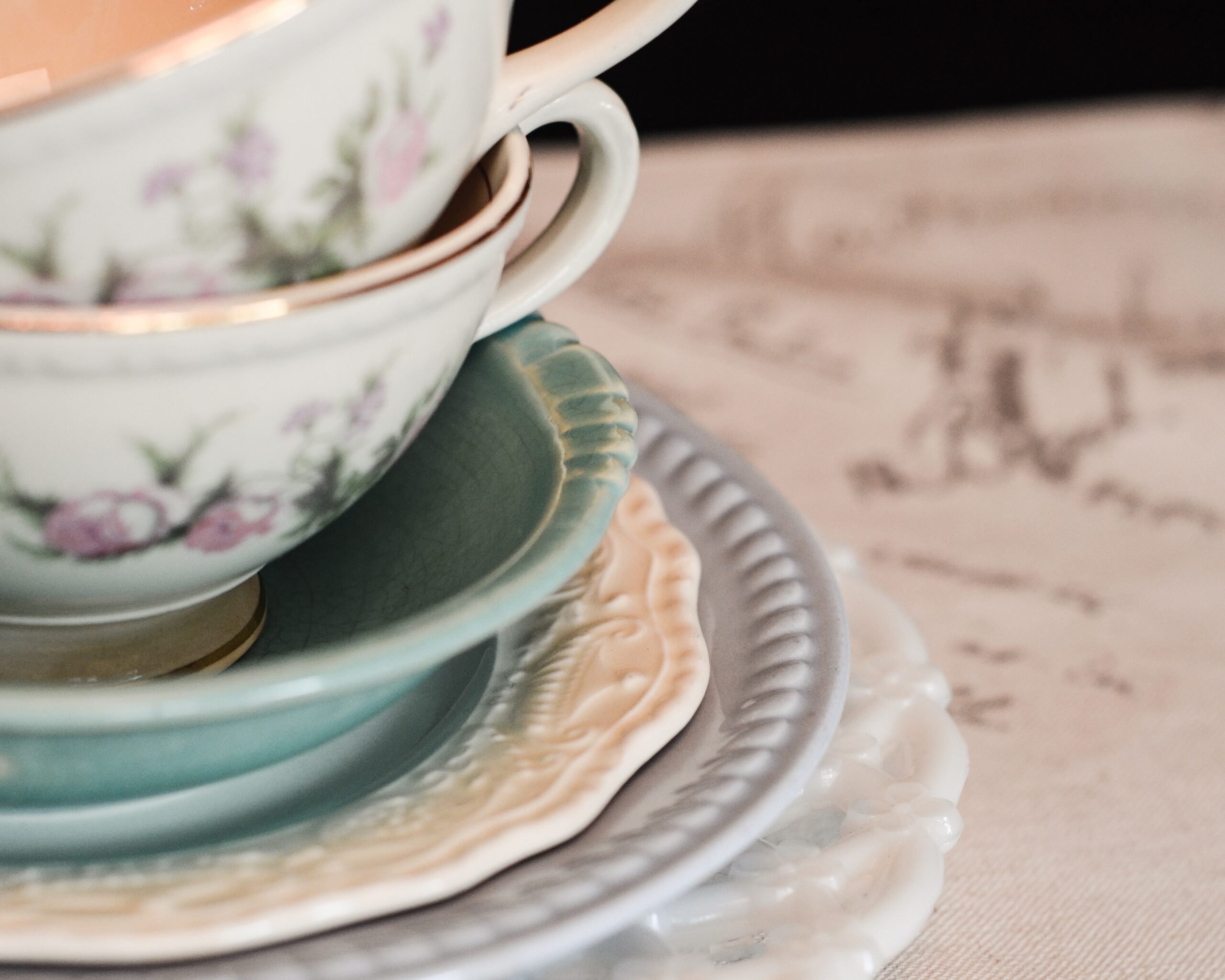 close up of a stack of antique teacups and saucers.